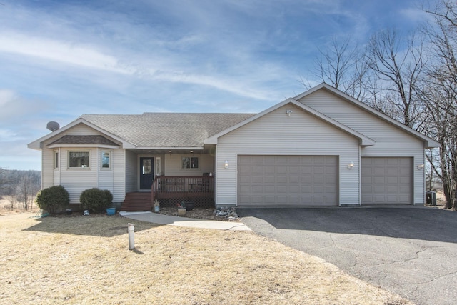 ranch-style house featuring a garage, a porch, driveway, and a shingled roof