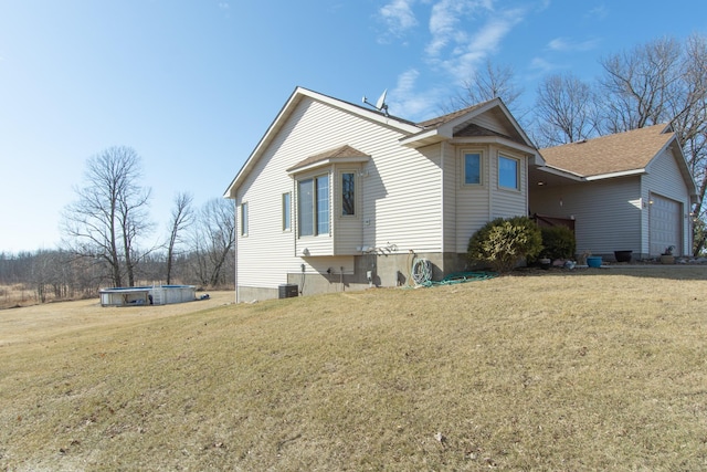 view of side of home featuring central air condition unit, a lawn, an outdoor pool, and a garage