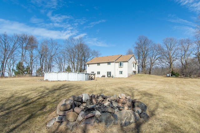 back of house featuring a swimming pool and a lawn
