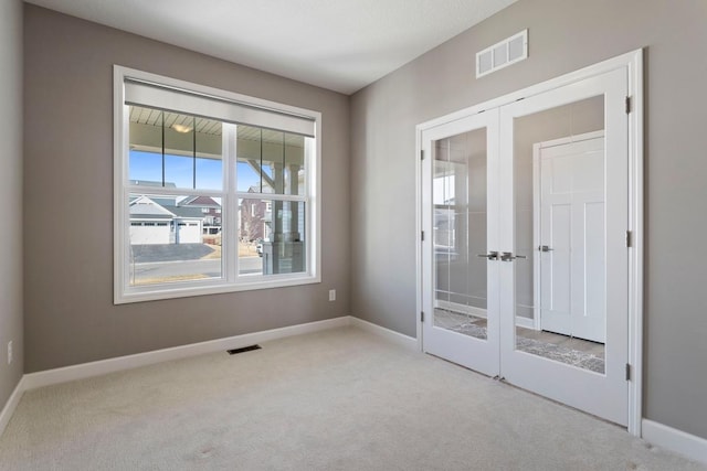 spare room featuring visible vents, french doors, baseboards, and carpet