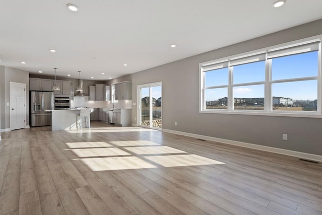 unfurnished living room featuring recessed lighting, visible vents, baseboards, and light wood-style flooring