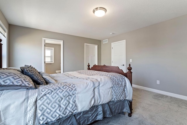 bedroom featuring visible vents, a textured ceiling, connected bathroom, carpet, and baseboards