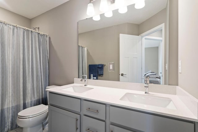 bathroom with curtained shower, double vanity, toilet, and a sink