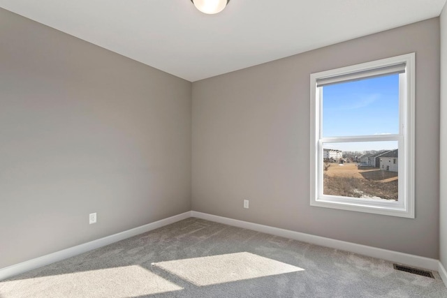 unfurnished room featuring carpet, visible vents, and baseboards