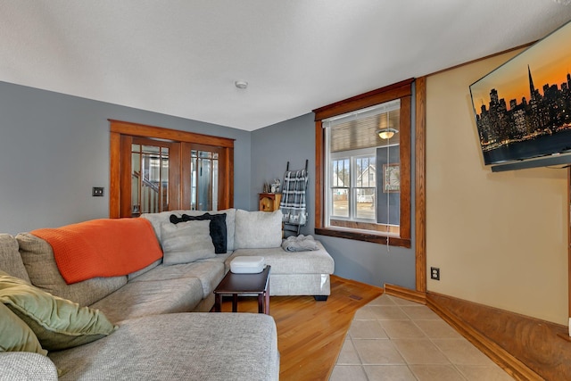 living area featuring baseboards and light tile patterned floors
