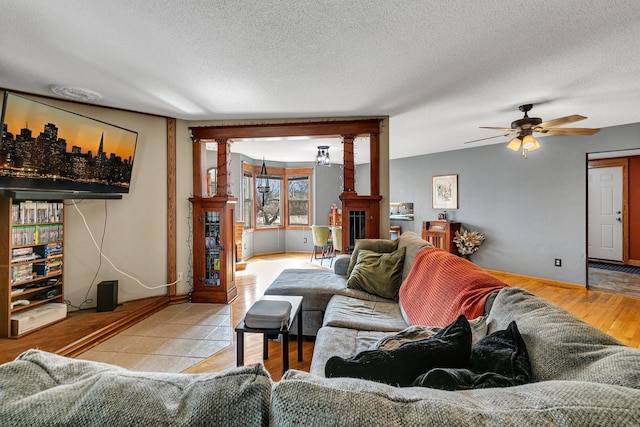 living area featuring a ceiling fan, wood finished floors, and a textured ceiling