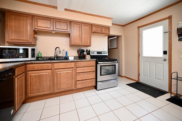 kitchen with dark countertops, crown molding, brown cabinetry, stainless steel appliances, and a sink