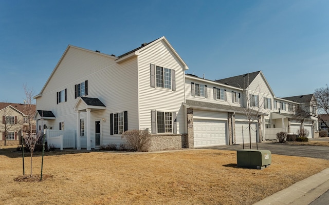 view of front of home with an attached garage, driveway, and fence