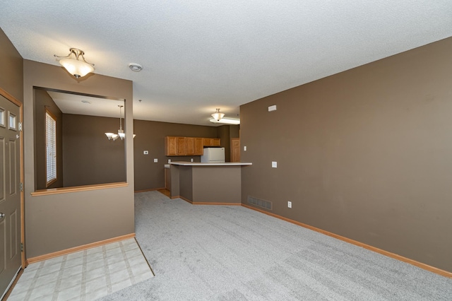 unfurnished living room featuring visible vents, baseboards, a textured ceiling, and an inviting chandelier