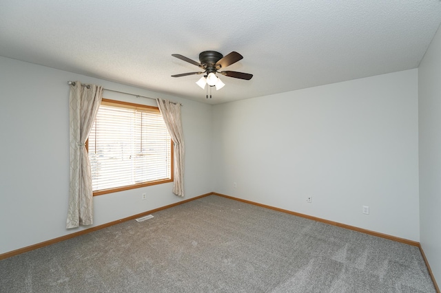 spare room with baseboards, a ceiling fan, visible vents, and a textured ceiling