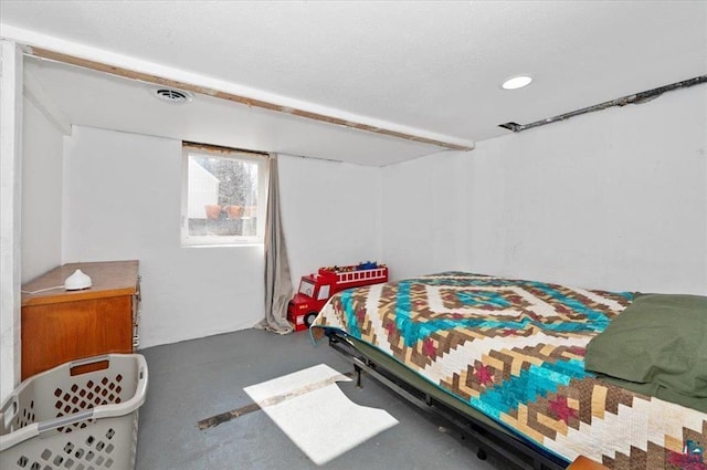 bedroom featuring visible vents, a textured ceiling, and concrete flooring