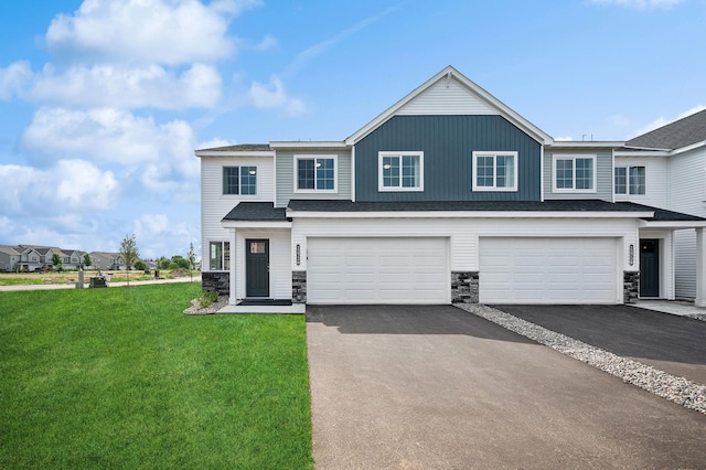 view of front of house with aphalt driveway, stone siding, a garage, and a front lawn