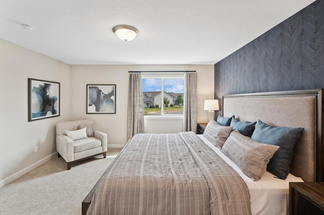 carpeted bedroom featuring an accent wall, baseboards, and wallpapered walls