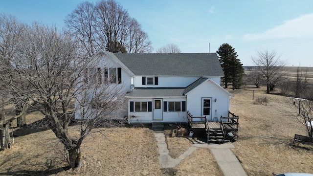 view of front of house featuring roof with shingles and a wooden deck