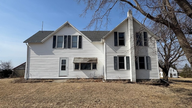 view of front of house featuring roof with shingles and a chimney