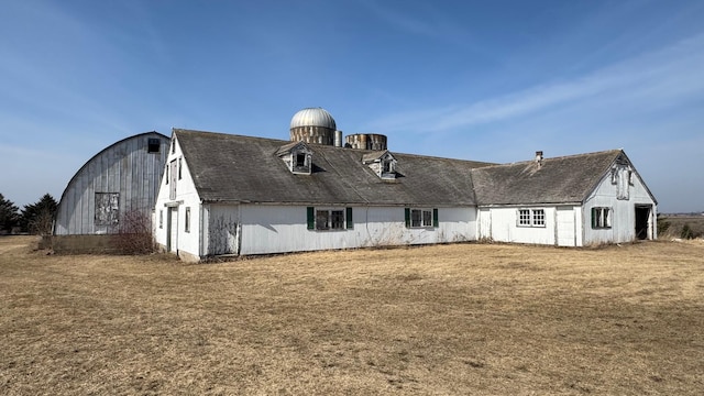 back of house featuring a yard, a barn, and an outdoor structure