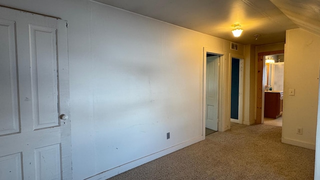 unfurnished bedroom with visible vents, baseboards, and light colored carpet