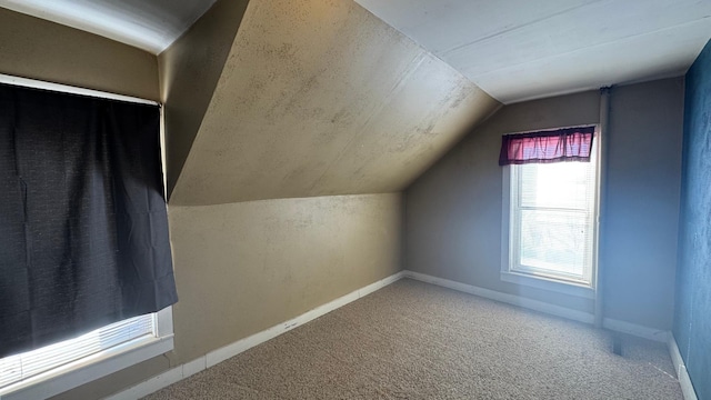 additional living space with baseboards, carpet floors, and lofted ceiling