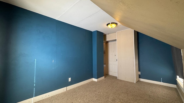 unfurnished bedroom with baseboards, lofted ceiling, and carpet floors