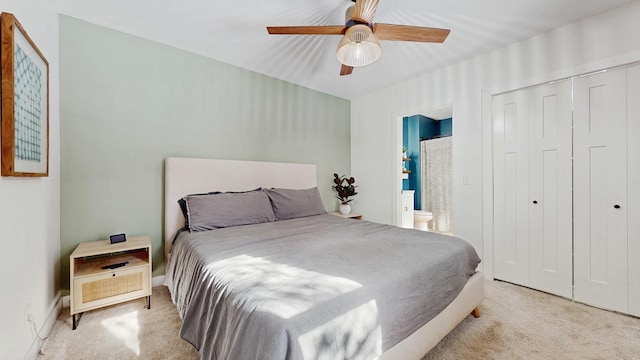 bedroom with a closet, ensuite bathroom, a ceiling fan, and carpet flooring