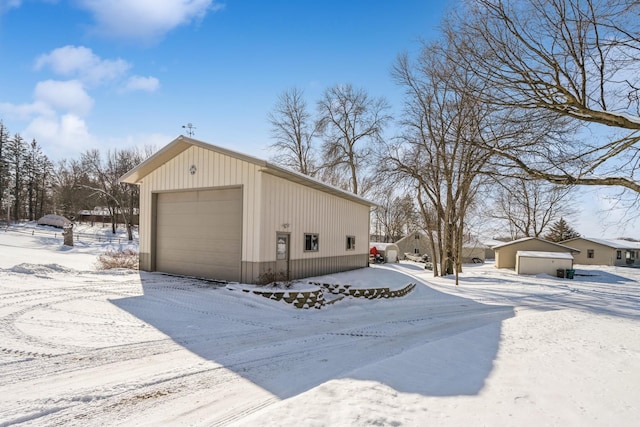 snow covered garage featuring a garage