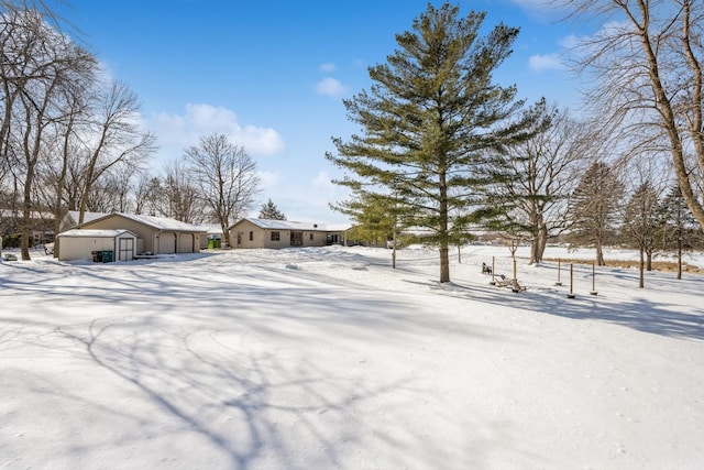 yard covered in snow featuring an outbuilding