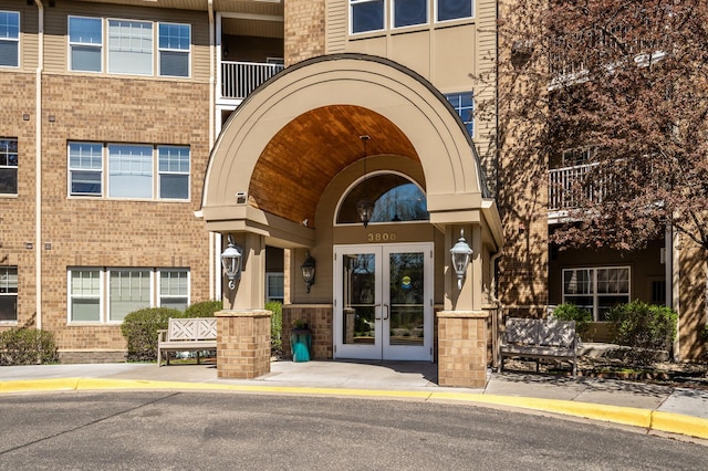 view of exterior entry with french doors and brick siding