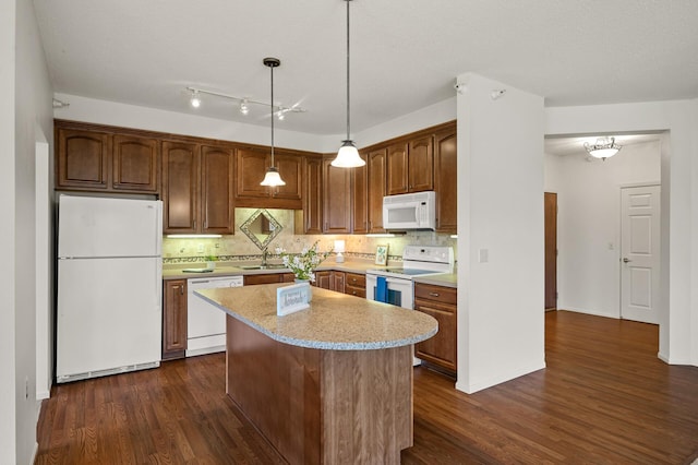 kitchen featuring white appliances, dark wood finished floors, a sink, and light countertops