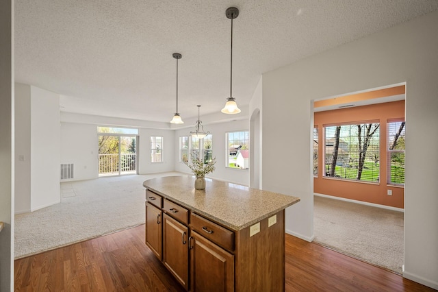 kitchen featuring visible vents, dark colored carpet, and open floor plan