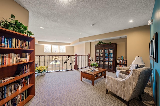 sitting room with carpet floors, recessed lighting, a textured ceiling, and a chandelier