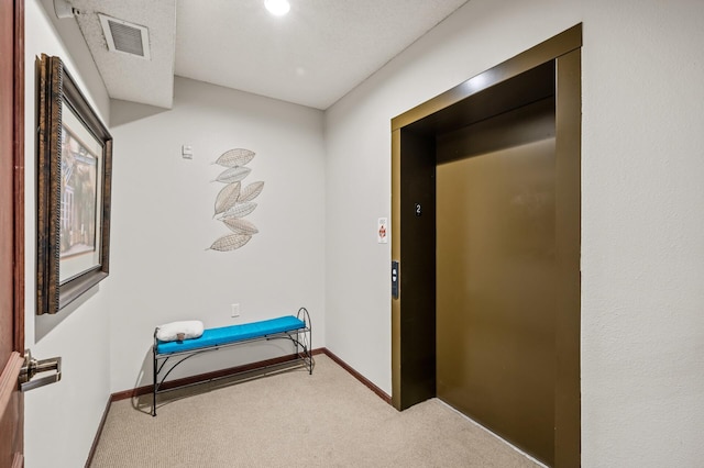 hall featuring baseboards, carpet, elevator, and visible vents