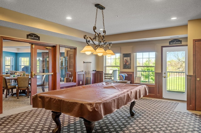 game room with a wainscoted wall, carpet flooring, a textured ceiling, and pool table