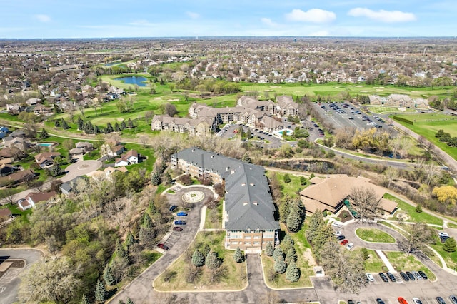drone / aerial view with a water view and view of golf course