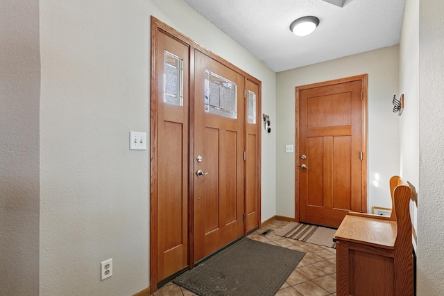 entryway featuring light tile patterned floors and baseboards