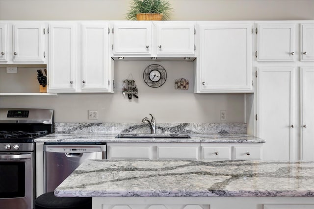 kitchen featuring light stone counters, open shelves, a sink, white cabinets, and appliances with stainless steel finishes