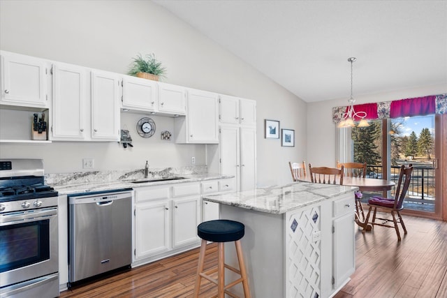 kitchen featuring a sink, lofted ceiling, white cabinets, and stainless steel appliances