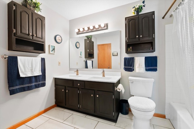 full bathroom with double vanity, toilet, baseboards, and a sink