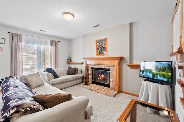 living room with visible vents, carpet floors, a textured ceiling, and a fireplace