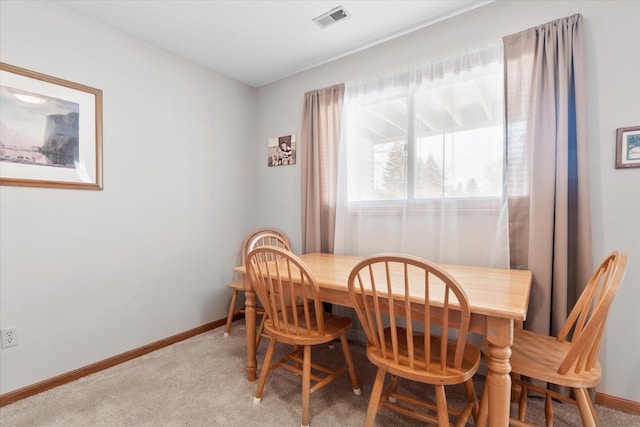 dining space featuring visible vents, light colored carpet, and baseboards