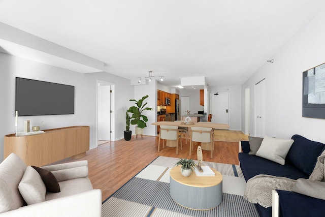 living area with light wood-type flooring and baseboards