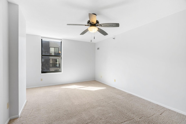 carpeted spare room with baseboards and ceiling fan