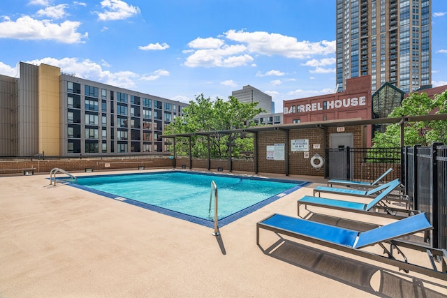 community pool featuring fence and a patio area