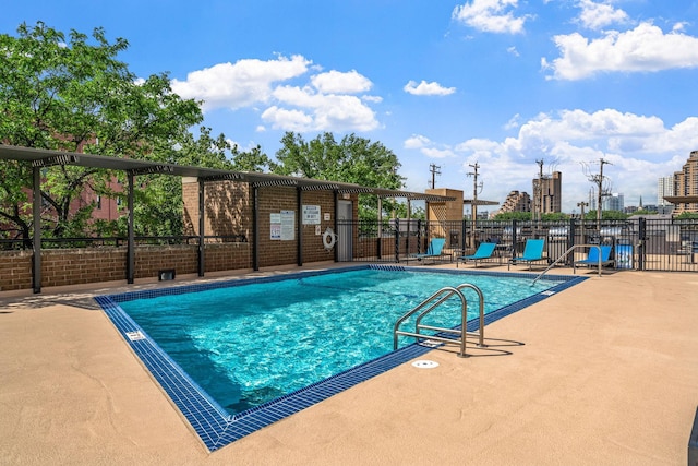 community pool featuring fence and a patio