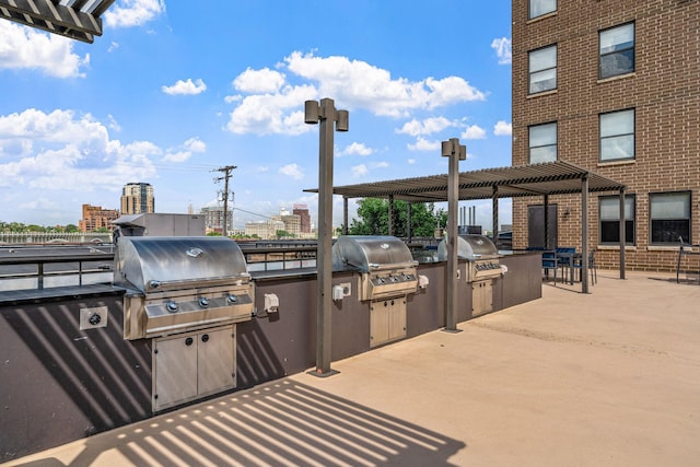 view of patio featuring exterior kitchen, area for grilling, and a pergola