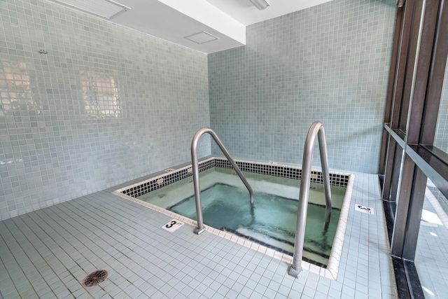 view of swimming pool with a hot tub
