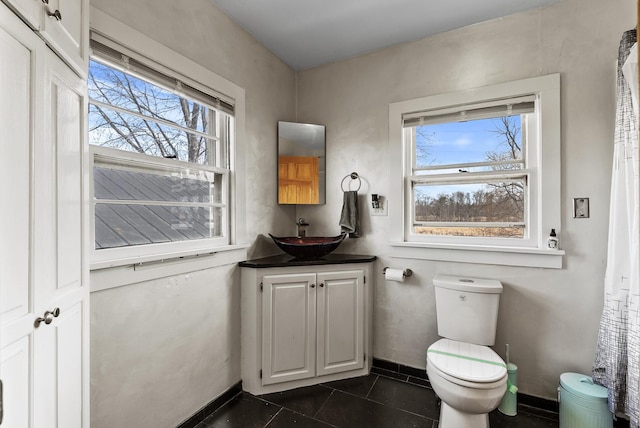 bathroom with tile patterned floors, toilet, vanity, and baseboards