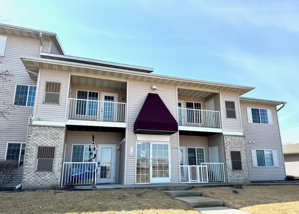 rear view of property featuring a porch and a balcony