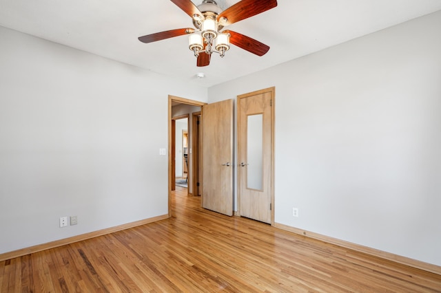 unfurnished room featuring light wood-style flooring, a ceiling fan, and baseboards