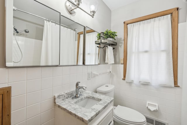 full bath featuring visible vents, toilet, vanity, a shower with shower curtain, and tile walls