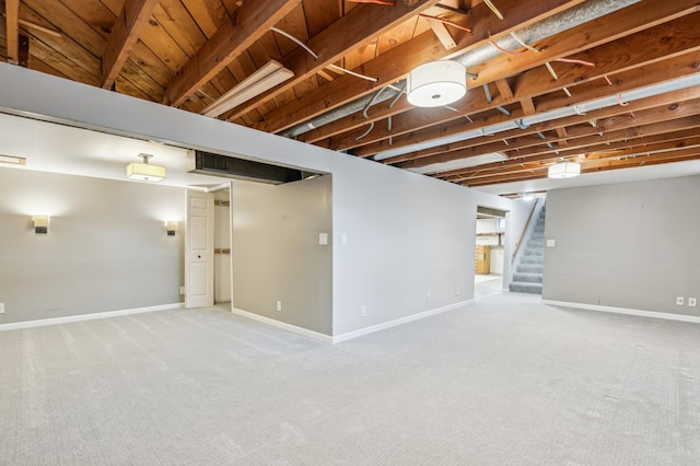 finished below grade area with stairway, baseboards, and carpet floors